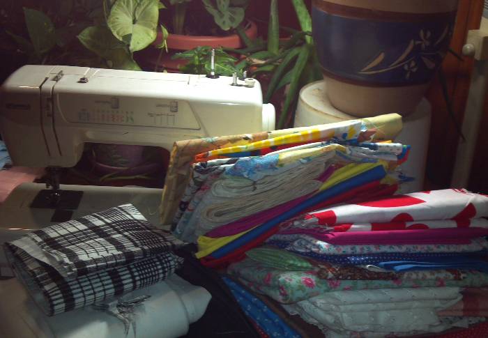 My sewing machine with stacks of fabric