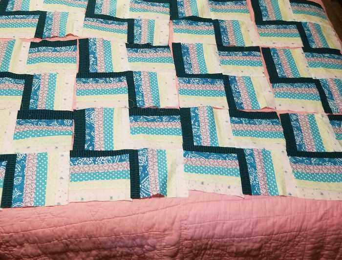 Quilt blocks laid out on a bed